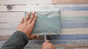 Unboxing a package with excitement and curiosity in a cozy setting video