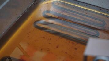 Examining the heating element in a frying oil container video
