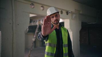 Serious dissatisfied Caucasian man showing hand gesture stop deny no build male guy builder reject not forbidden keep distance refusal sign worker repairman architect construction engineer contractor video
