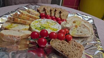 Wooden board with grapes, tomatoes, cheese, rustic aesthetic of farm-to-table produce, perfect for relaxed picnic setting in countryside atmosphere. video