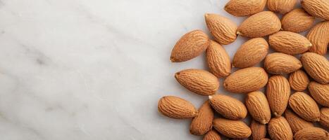 A close-up view of scattered almonds on a marble surface, showcasing their textured shells and natural color. photo