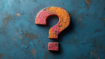Colorful question mark displayed on a textured blue surface captures curiosity and imagination in a creative setting photo