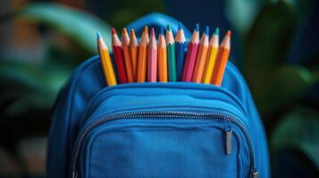 Bright colored pencils arranged in a blue backpack with greenery in the background during a sunny day photo