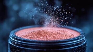 Fine particles of cosmetic powder hovering above a black container in soft light photo