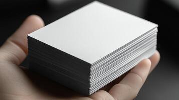 Stacked blank business cards held in hand ready for customization and printing in a modern workspace photo
