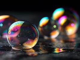 Translucent soap bubbles showcasing rainbow colors and reflections rest on a dark surface, casting vibrant highlights. The focus is on the foreground bubble. Text is not present photo