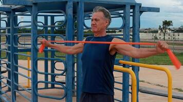 Man outdoors at the Park using a fitness Rubber band or Stretch Bands for increase mobility and Strength video