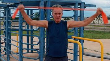 Man 60 Plus at the Park using a fitness Rubber band or Stretch Bands for increase mobility and Strength video