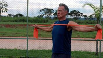 Slow Motion of a Mature Man at the Park using a fitness Rubber band or Stretch Bands for increase mobility and Strength video