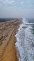 Drone Circles Sandy Beach with Dunes and Rolling Waves video