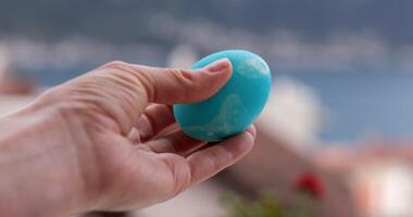 Coloring Easter eggs in turquoise shade for festive celebrations while enjoying a scenic view photo