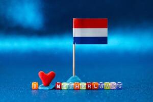 Colorful decorations displaying love for Netherlands with a small flag and heart on a vibrant blue surface during an artistic arrangement photo