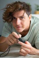 Portrait of handsome excited gamer lying on a bed and playing games on a console. Wireless controller and online game technologies concept photo