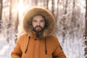 Man in winter coat standing in snowy forest at sunrise. Solitude, connection with nature, and quiet winter contemplation outdoors. Copy space photo