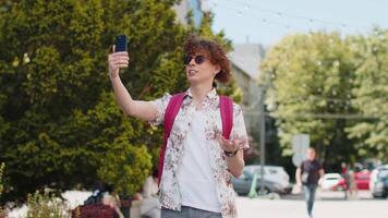 Tourist man blogger taking selfie on smartphone, communicating call online with subscribers video