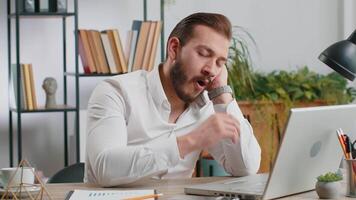 Bored sleepy business man worker working on laptop computer, yawning, falling asleep at home office video