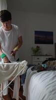 A dedicated person is methodically organizing their laundry in a bright and cozy bedroom setting video