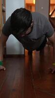 A Young Man Engaging in PushUps as a Part of His Fitness Routine at Home for Exercise video