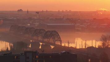 Sunrise over Riga, Latvia, with the Latvian Academy of Sciences, Daugava River, railway bridge, morning mist, and smoke rising from chimneys. video
