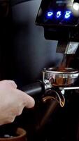 Barista grinding beans with professional equipment, close-up of precision espresso process, showcasing quality coffee-making, grinder in motion, and skilled preparation techniques, vertical . video