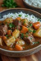 Bowl of hearty beef stew with potatoes and carrots, served with rice photo