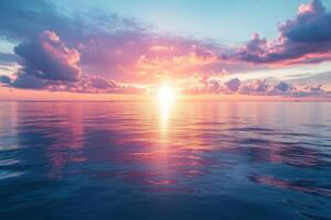 Pink and blue sunset reflecting on calm ocean with clouds photo