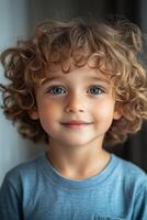Portrait of smiling toddler with big blue eyes and curly blond hair photo