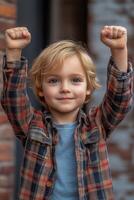 Portrait of happy child raising fists in the air celebrating victory photo