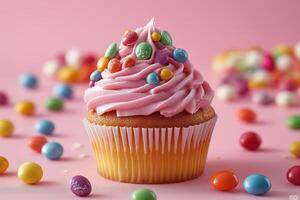 A cupcake with pink frosting and candy sprinkles photo