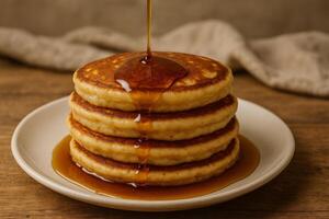 A stack of pancakes with syrup being poured over them photo