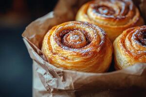 Three cinnamon rolls in a paper bag photo