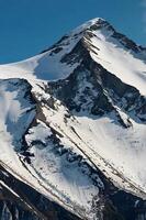A mountain with snow on it and a blue sky photo