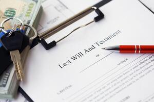Pen and keys on Last will and testament form and planning blueprints of residential building project photo