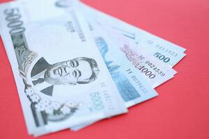 North Korean won money in big amount lies on red color table close up photo