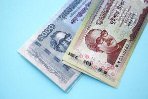 Bangladeshi money in big amount lies on teal color table photo
