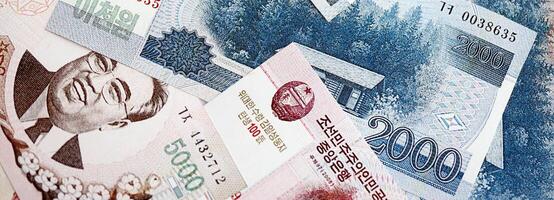 North Korean won money bills in big amount lies on white color table close up photo