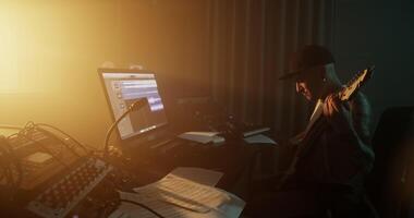 Sound engineer playing guitar and using computer in studio video