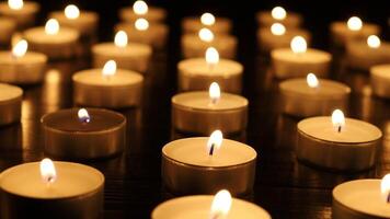 Many lit candles are arranged in rows video