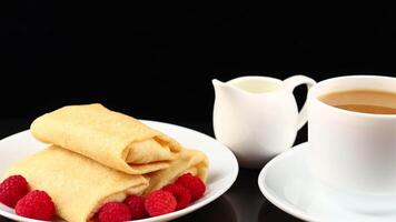 Breakfast with crepes and raspberries on a black background video