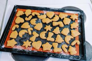Ruddy Christmas cookies lie on a baking sheet on the stove photo