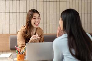 Communication and Interaction. A student animatedly discussing concepts with a classmate at the table. photo
