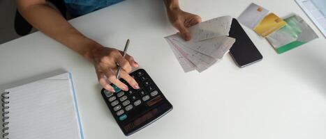 Financial Planning and Expense Management. A person calculating bills while organizing multiple receipts. photo