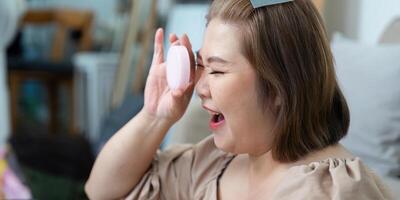 Makeup Application and Joy. A woman playfully applying makeup while smiling, emphasizing a vibrant beauty routine. photo
