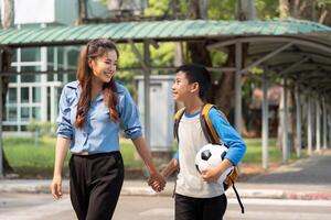 A Moment of Connection. A mother and son sharing smiles and aspirations on their way to school with a soccer ball. photo