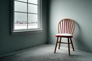 Empty chair by the window in a snowy room during winter brings a sense of solitude photo