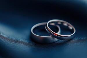 Elegant silver wedding rings resting on dark fabric, symbolizing love and commitment photo