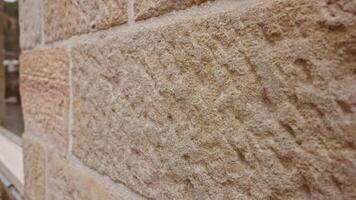 An extreme close-up of a weathered sandstone brick from a historic building, revealing its intricate texture and geological patterns. video