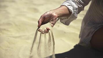 Female hand against sand background with quartz silicon oxide slowly sifting through fingers. Showcases this versatile material used in construction and microchips. video
