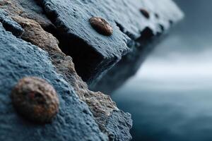 Close-up view of weathered metal bolts on a rugged rock surface near water photo