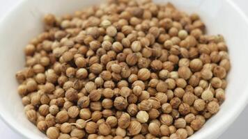 Dried coriander seeds in a close-up in a white cup. Seasoning for dishes, drinks and marinades. Coriander seeds, coriander peas, aromatic spice video